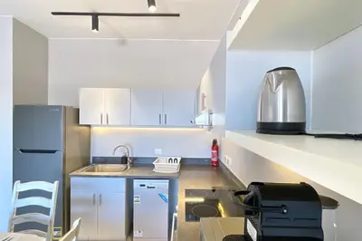a kitchen with white cabinets and a sink at Cordial 2 BDR w Pool Access Cyan El Gouna in Hurghada