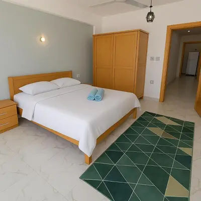 a bedroom with a large bed with two blue pillows on it at LUXOR DREAM - Panoramic Villa in Luxor