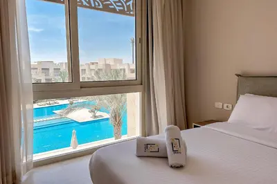 a hotel room with a bed and a large window at Stellar 1BDR Mangroovy Free Pool & Beach Access in Hurghada