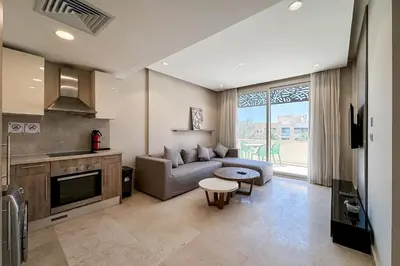a living room with a couch and a table at Stellar 1BDR Mangroovy Free Pool & Beach Access in Hurghada