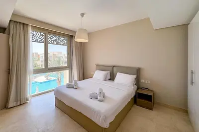 a bedroom with a large bed and a large window at Stellar 1BDR Mangroovy Free Pool & Beach Access in Hurghada