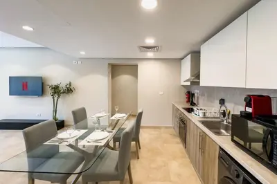 a kitchen with a glass table and chairs in a kitchen at Soothing & Stilly 2BDR Mangroovy Pool & Beach Access in Hurghada