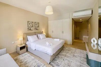 a bedroom with a large white bed and a couch at Summer Breeze 2 BDR Pool Sea View Mangroovy in Hurghada