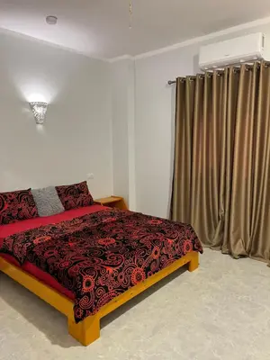 a bedroom with a bed and a window with curtains at Villa Muhammad in Quseir