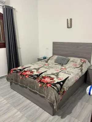 a bedroom with a bed with a floral comforter at Villa Muhammad in Quseir