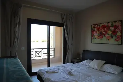 a bedroom with a bed and a door to a balcony at Water front luxury 3BD villa in Hurghada