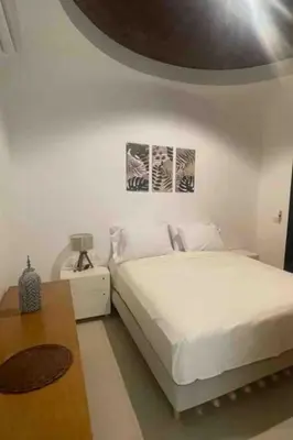 a white bedroom with a bed and a table at 3 Bedrooms with roof in Makadi in Hurghada