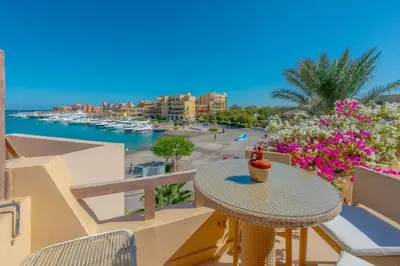 a table on a balcony with a view of a beach at Luxury apartment on the Marina in Hurghada