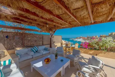 a patio with white furniture and a view of the ocean at Luxury apartment on the Marina in Hurghada