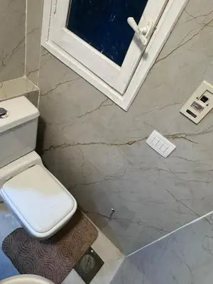a bathroom with a toilet and a window at Mastaba Village Hurgada House in Hurghada