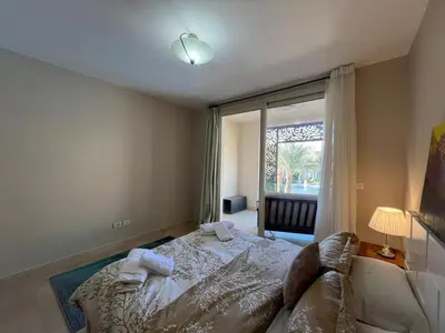 a bedroom with a bed and a large window at M Residence with Pool View & Beach Access - El Gouna, Hurghada in Hurghada