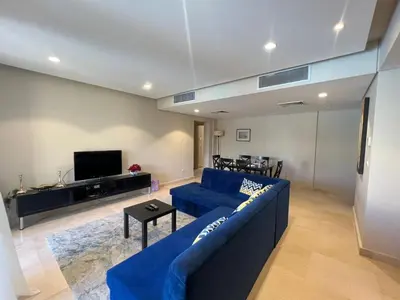 a living room with a blue couch and a tv at M Residence with Pool View & Beach Access - El Gouna, Hurghada in Hurghada