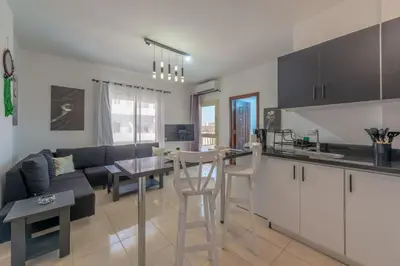 a kitchen and living room with a couch and a table at Luxury apartment on the pool in Hurghada