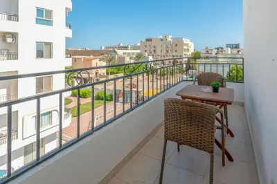 a balcony with a table and chairs and a view at Luxury apartment on the pool in Hurghada