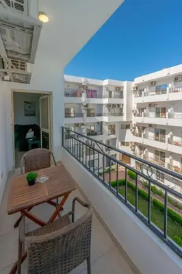 a balcony with a table and chairs on a building at Luxury apartment on the pool in Hurghada