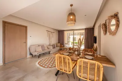 a living room with a table and chairs at Secluded & Bespoke 1 BDR Apt with Pool View & Beach access in Hurghada
