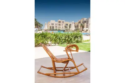 two wooden rocking chairs sitting next to a pool at Secluded & Bespoke 1 BDR Apt with Pool View & Beach access in Hurghada