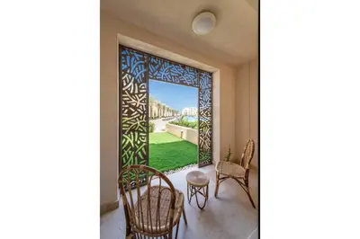 a room with a view of a garden through a window at Secluded & Bespoke 1 BDR Apt with Pool View & Beach access in Hurghada