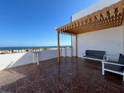 a room with a couch and a table on a roof at Kite and Dive Home in Hurghada