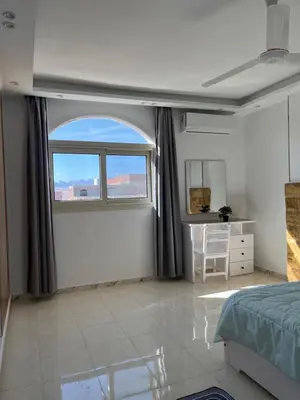 a bedroom with a window and a bed and a desk at Kite and Dive Home in Hurghada