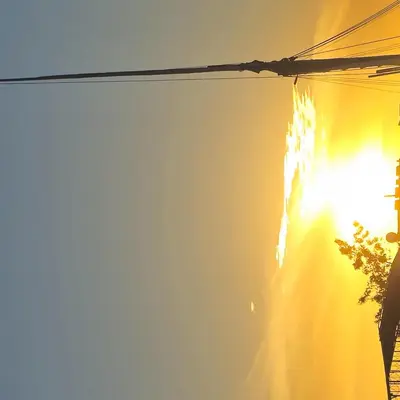 a street light with the sun shining on a building at Nanis Guest House Nile View in Luxor