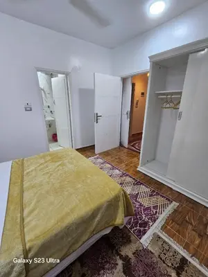 a bedroom with a bed in a room with open doors at Nanis Guest House Nile View in Luxor