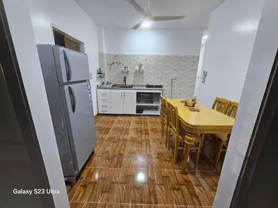 a kitchen with a refrigerator and a table with chairs at Nanis Guest House Nile View in Luxor