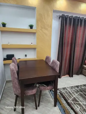 a wooden table with two chairs and a curtain at Abeer Suites 5 in Hurghada