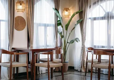 a dining room with a table and chairs and a plant at Aro Kato Nubian Guest House in Aswan