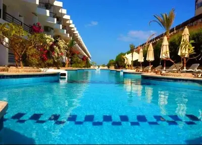 a swimming pool with blue water in a resort at Capitan house beside Bellagio hotel 5 minutes from El gouna in Hurghada