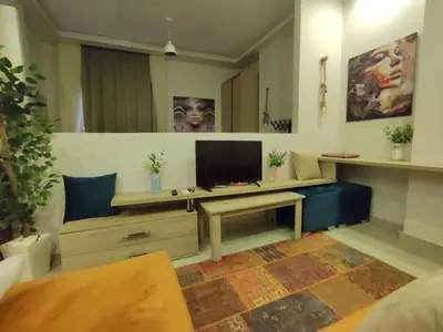 a living room with a tv and a blue couch at Capitan house beside Bellagio hotel 5 minutes from El gouna in Hurghada