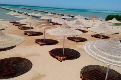 a group of umbrellas and chairs on a beach at Capitan house beside Bellagio hotel 5 minutes from El gouna in Hurghada