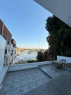 a patio with two chairs and a view of the water at BePy's NUBIAN HOUSE in Aswan