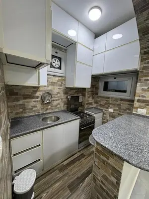 a kitchen with white cabinets and a counter top at BePy's NUBIAN HOUSE in Aswan