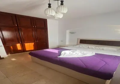 a bedroom with a large bed with purple sheets at Warm One Bedroom at West Golf Y62 in Hurghada