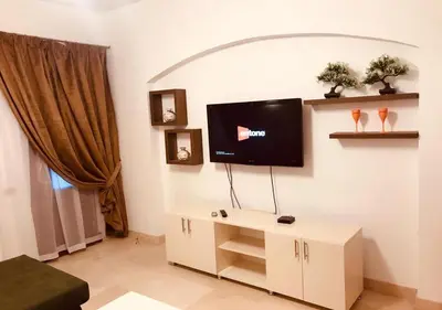 a living room with a flat screen tv on a wall at Warm One Bedroom at West Golf Y62 in Hurghada