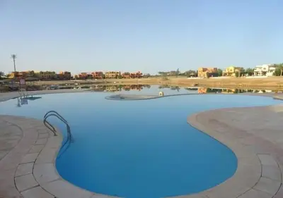 a large pool with blue water in the middle at Warm One Bedroom at West Golf Y62 in Hurghada