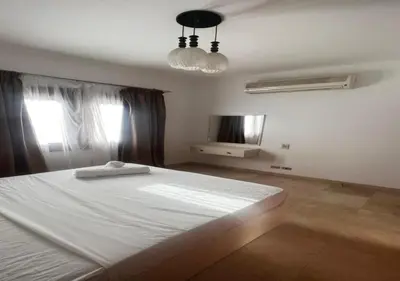 a bedroom with a white bed and a television at Warm One Bedroom at West Golf Y62 in Hurghada