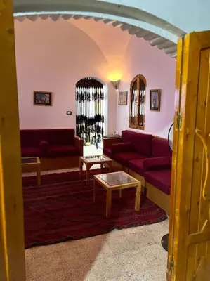 a living room with a red couch and a table at Shamandy house same same but different in Jazīrat Aswān