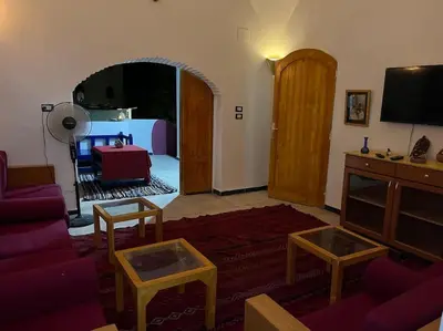a living room with a couch and a tv at Shamandy house same same but different in Jazīrat Aswān