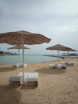 a group of umbrellas and chairs on a beach at Scandic Resort Hurghada Red Sea in Hurghada