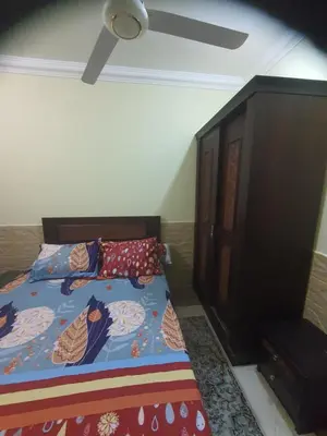 a bedroom with two beds and a wooden cabinet at Abeer Suites 4 basement in Hurghada