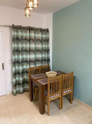 a dining room with a table and chairs and a curtain at Enjoy Makadi Heights Red Sea in Hurghada
