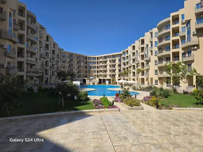 a large apartment building with a swimming pool in the foreground at Sea view Prinessa Resort in Hurghada