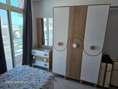 a bedroom with two white cabinets and a bed at Sea view Prinessa Resort in Hurghada