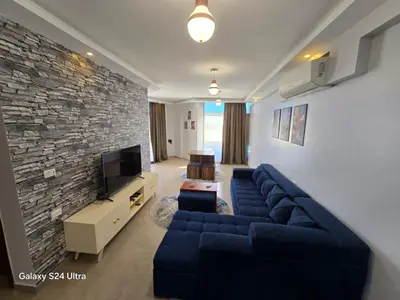 a living room with a blue couch and a stone wall at Sea view Prinessa Resort in Hurghada