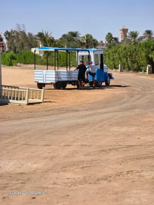 a man is standing next to a bus on a dirt road at Sea view Princessa Resort in Hurghada