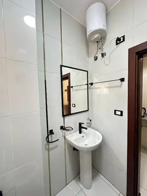 a white bathroom with a sink and a mirror at Downtown Keys in Hurghada