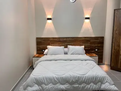 a bedroom with a large bed with lights above it at Downtown Keys in Hurghada