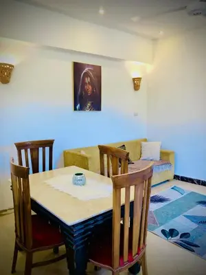 a dining room with a table and a couch at Moka Gust House in Luxor